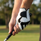 Gloved hand gripping a club on the course