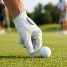 Gloved hand placing a magnetic ball marker on the green