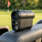 Golf rangefinder resting on a golf cart on the course
