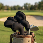 Iron head covers on irons in a golf bag on the course